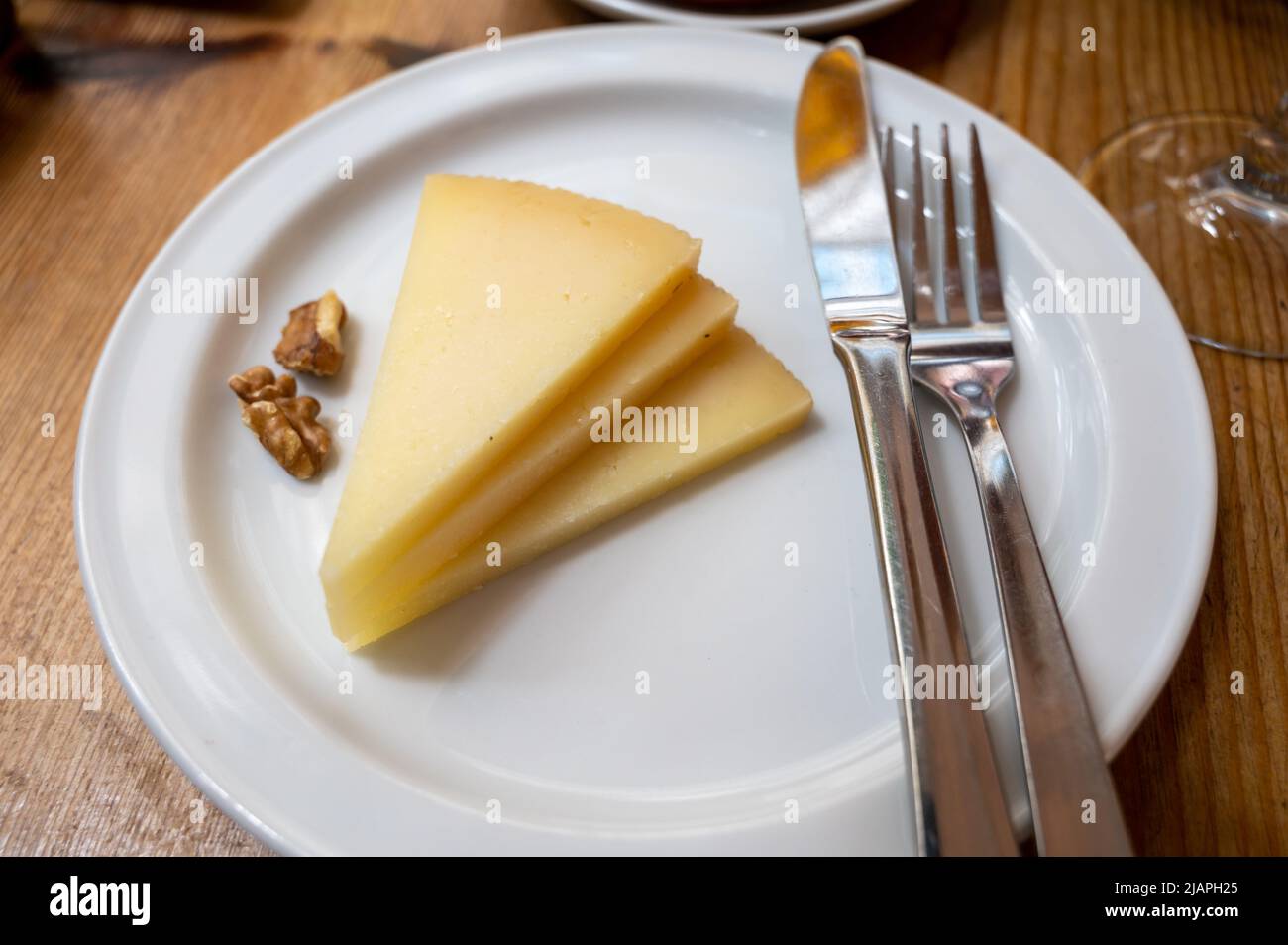 Tasting of Spanish cheeses, manchego curado cheese on white board Stock