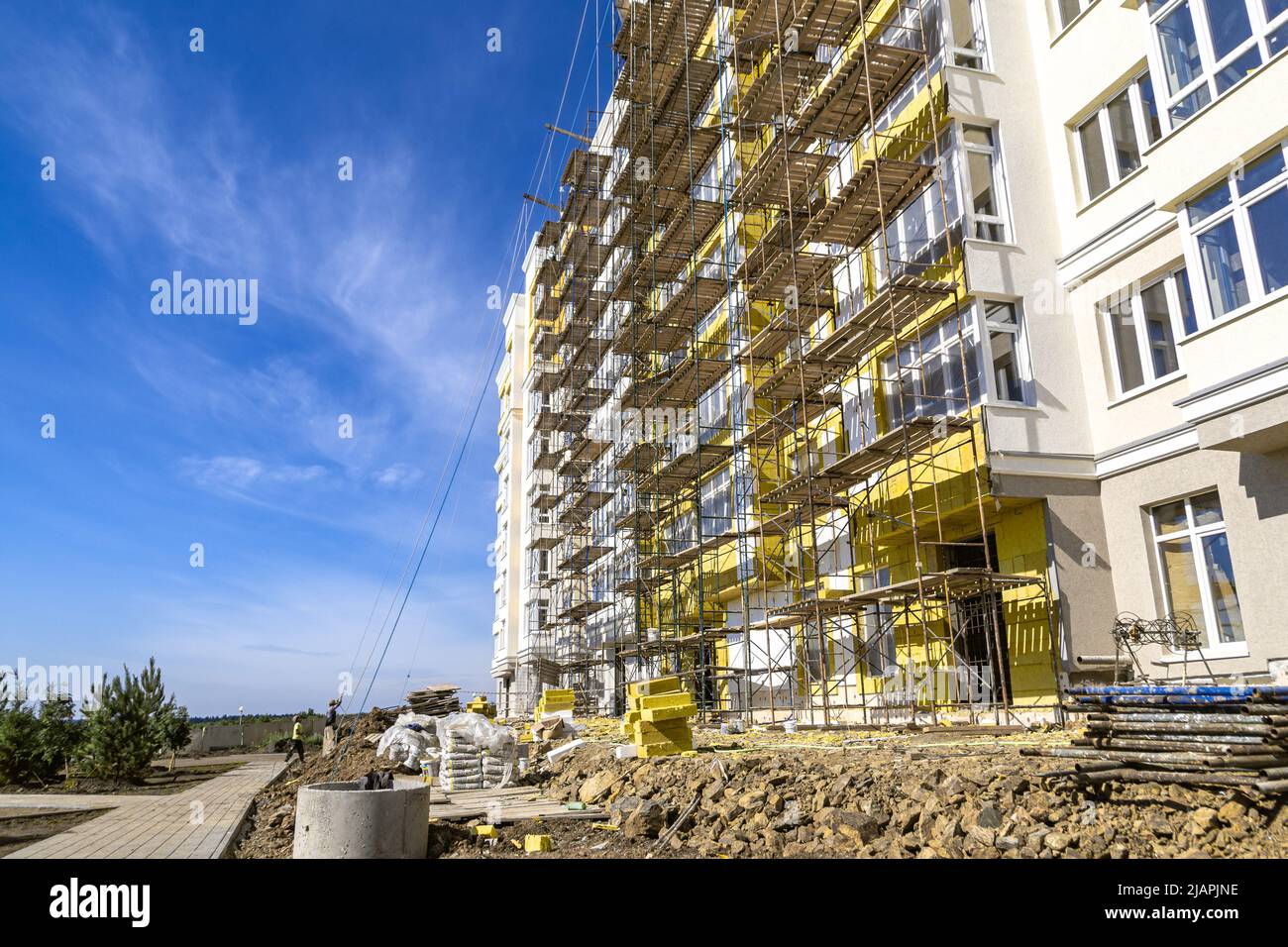 scaffolding for facade decoration is installed near the walls of a multi-storey residential building, selective focus Stock Photo