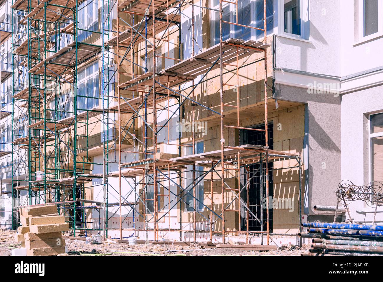 finishing the facade of a residential building using scaffolding, selective focus Stock Photo