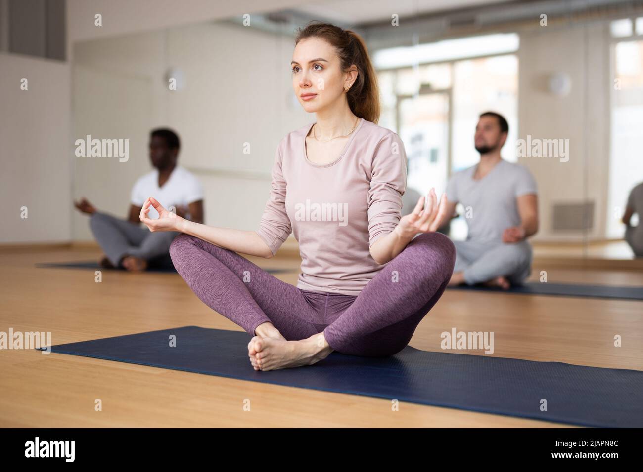 Woman sitting in butterfly pose with hands folded in mudra Stock Photo ...