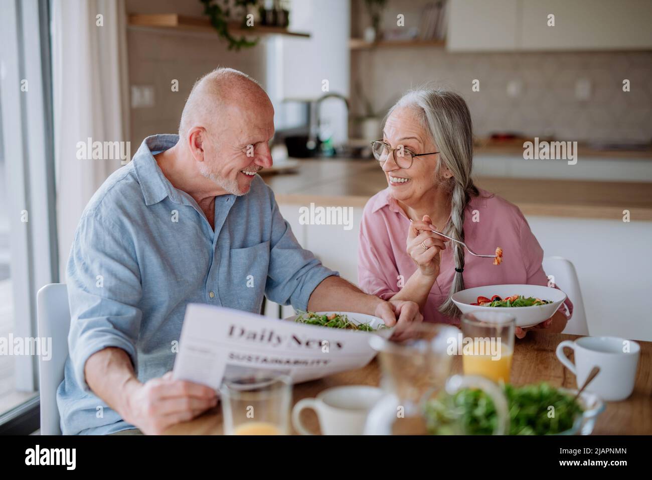 Happy senior couple eating dinner together at home. Stock Photo