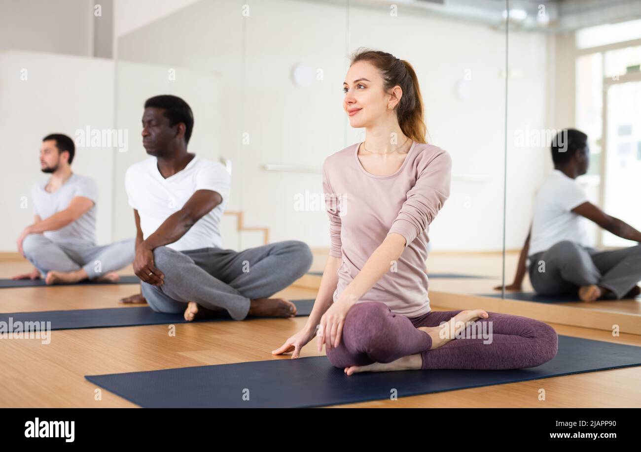 Woman sitting in lotus pose, group training Stock Photo - Alamy