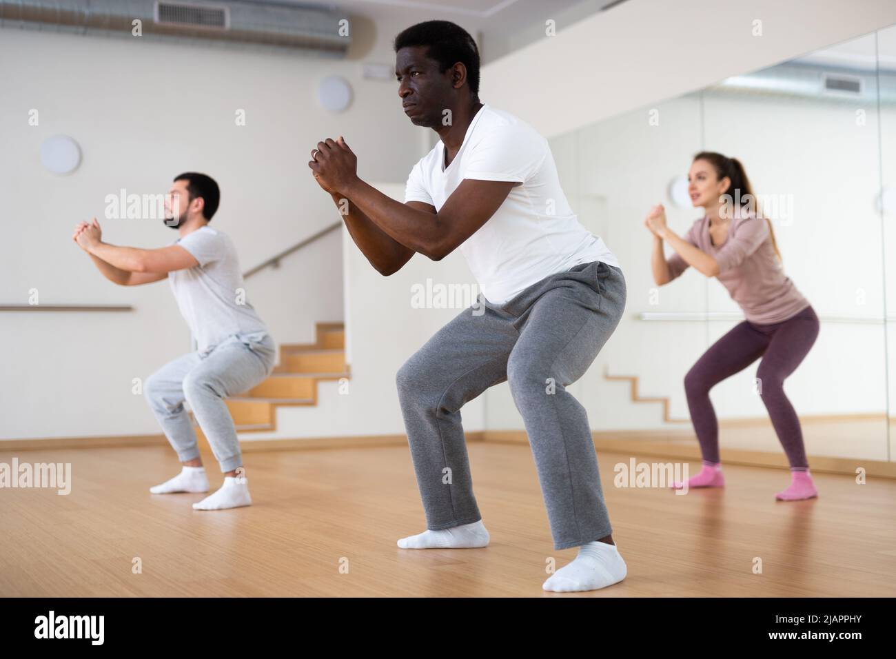 People squatting during fitness training Stock Photo Alamy