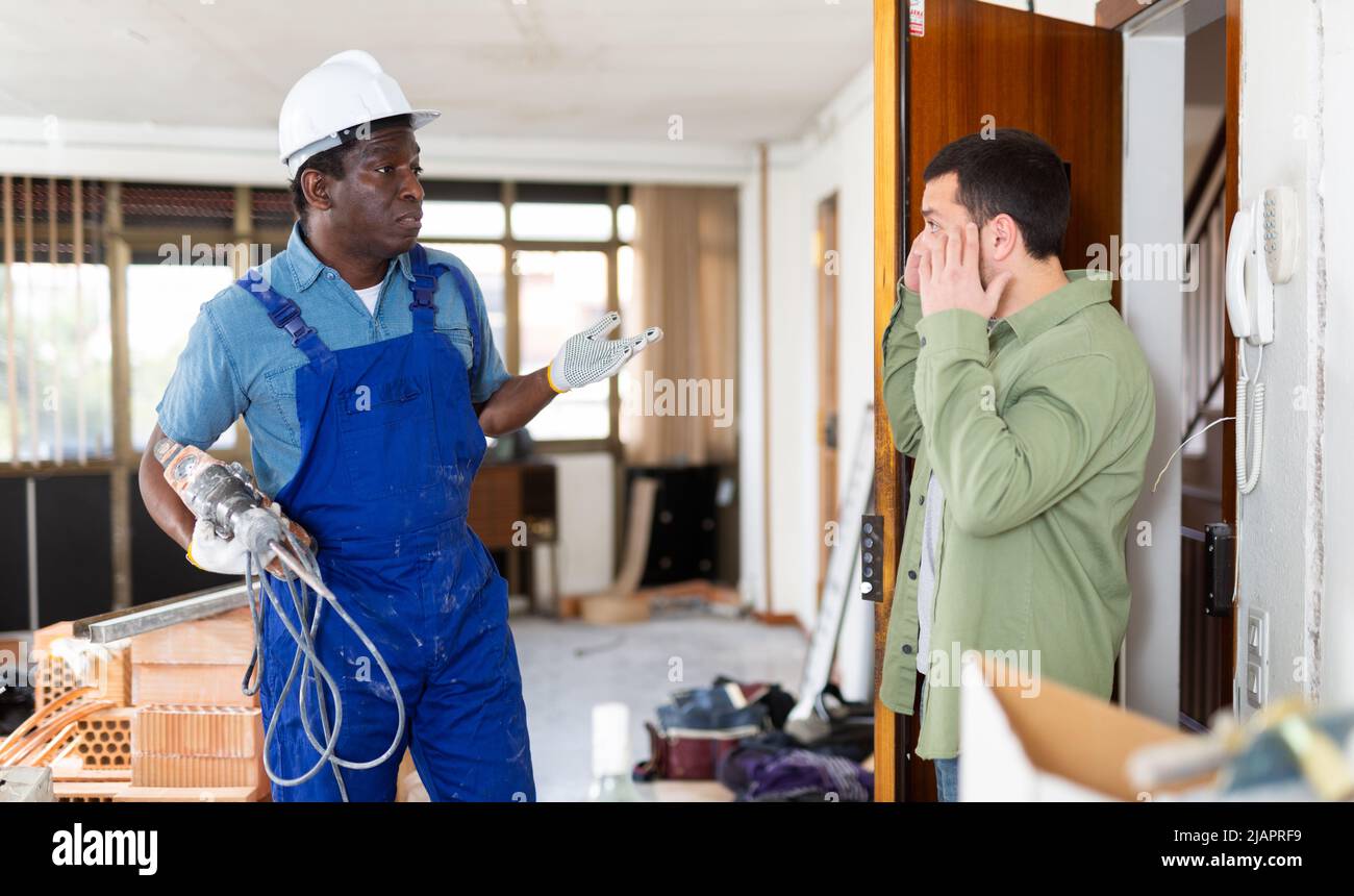 Neighbor complaining about noise to builder Stock Photo - Alamy