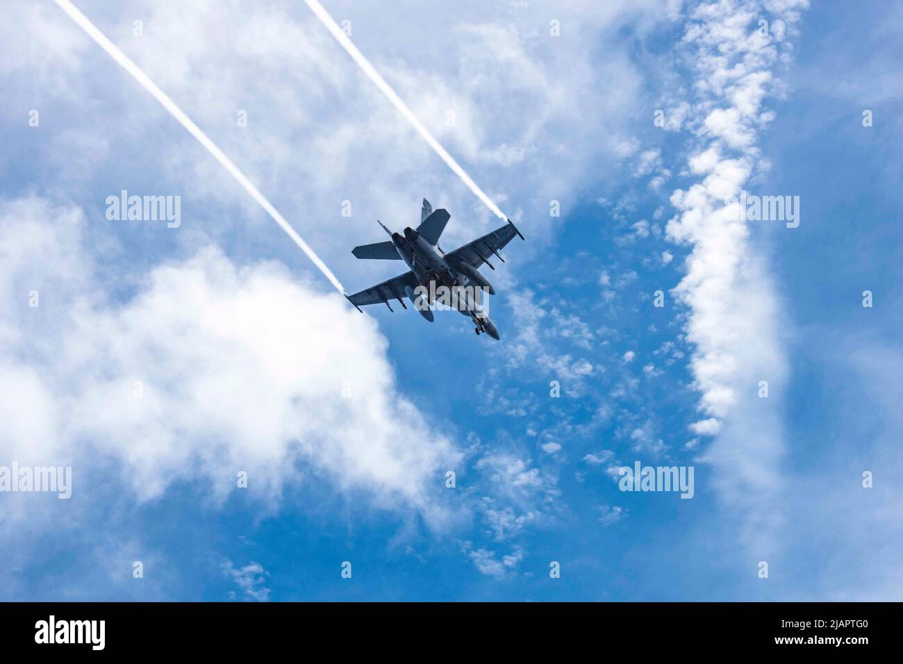 May 21, 2022 - Pacific Ocean - An F/A-18F Super Hornet, attached to the Diamondbacks of Strike Fighter Squadron (VFA) 102, flies over the flight deck of the U.S. Navys only forward-deployed aircraft carrier USS Ronald Reagan (CVN 76) during carrier qualifications. Ronald Reagan and Carrier Air Wing (CAG) 5 are conducting carrier qualifications to certify the ship and embarked squadrons are fully capable for at sea flight operations. Ronald Reagan, the flagship of Carrier Strike Group 5, provides a combat-ready force that protects and defends the USA, and supports alliances, partnerships and co Stock Photo