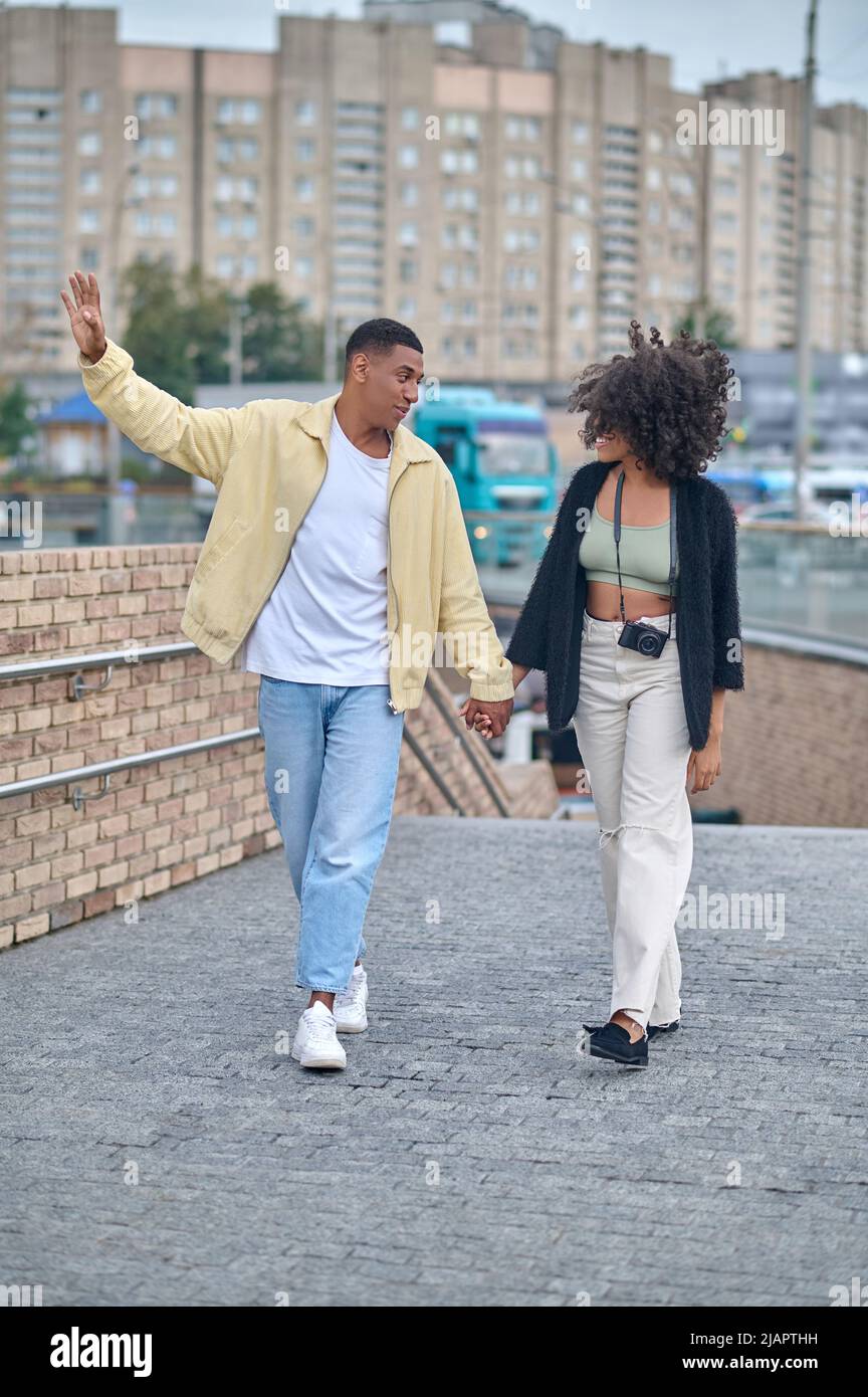 Guy and girl walking looking at each other Stock Photo Alamy