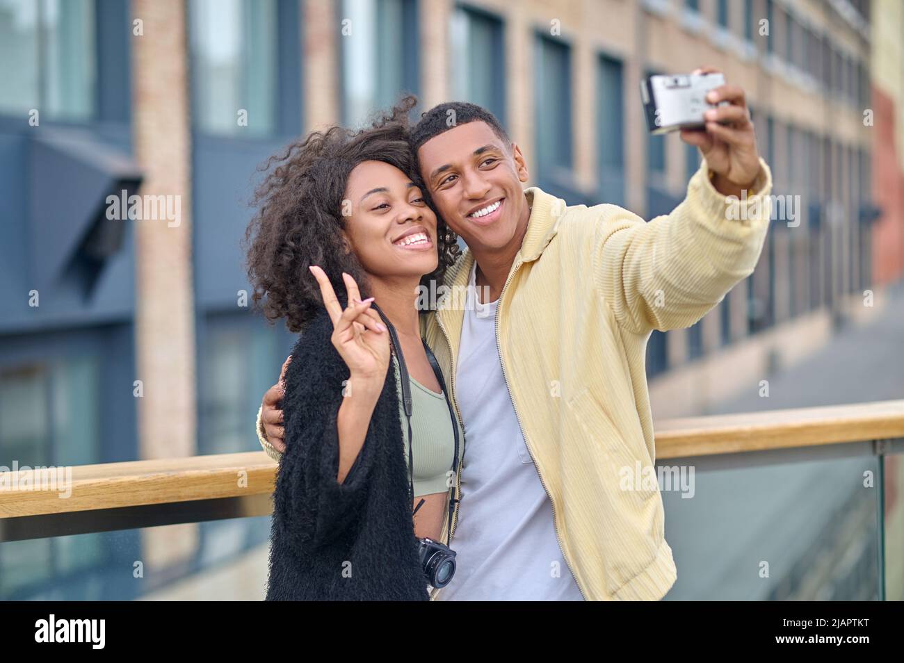 Guy hugging smiling girlfriend taking selfie on camera Stock Photo
