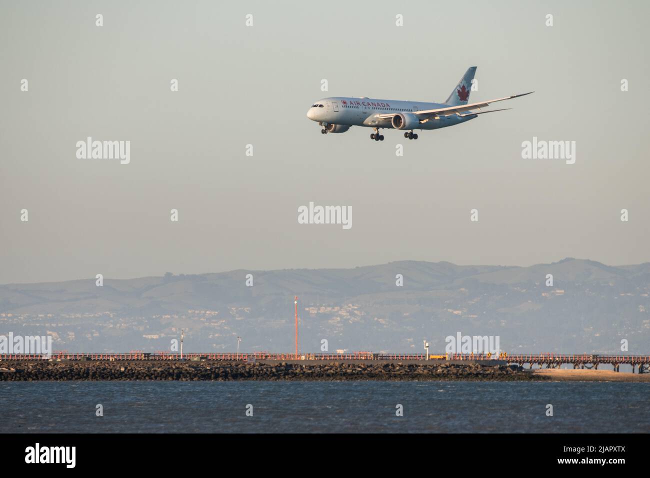 A landing Air Canada flight, the plane descends towards the runway at San Francisco International airport, California, USA. Stock Photo