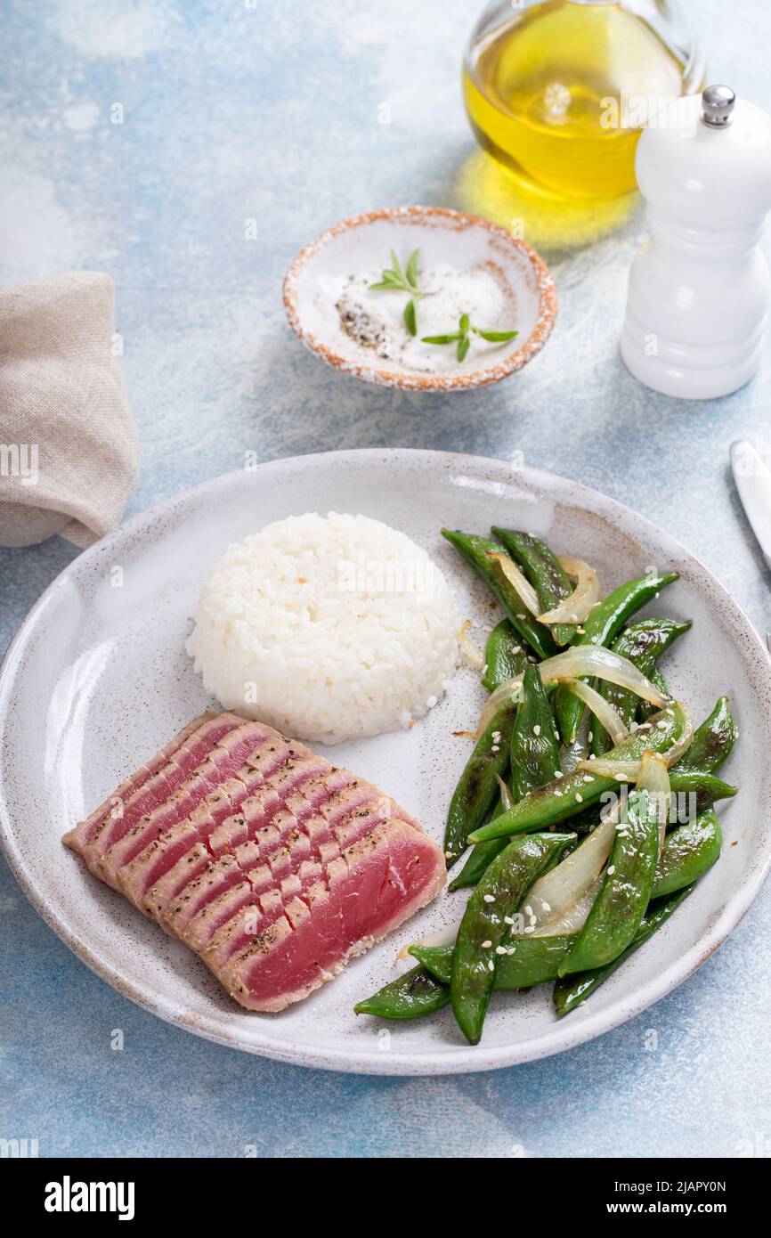 Seared tuna steak with white rice and green peas Stock Photo Alamy