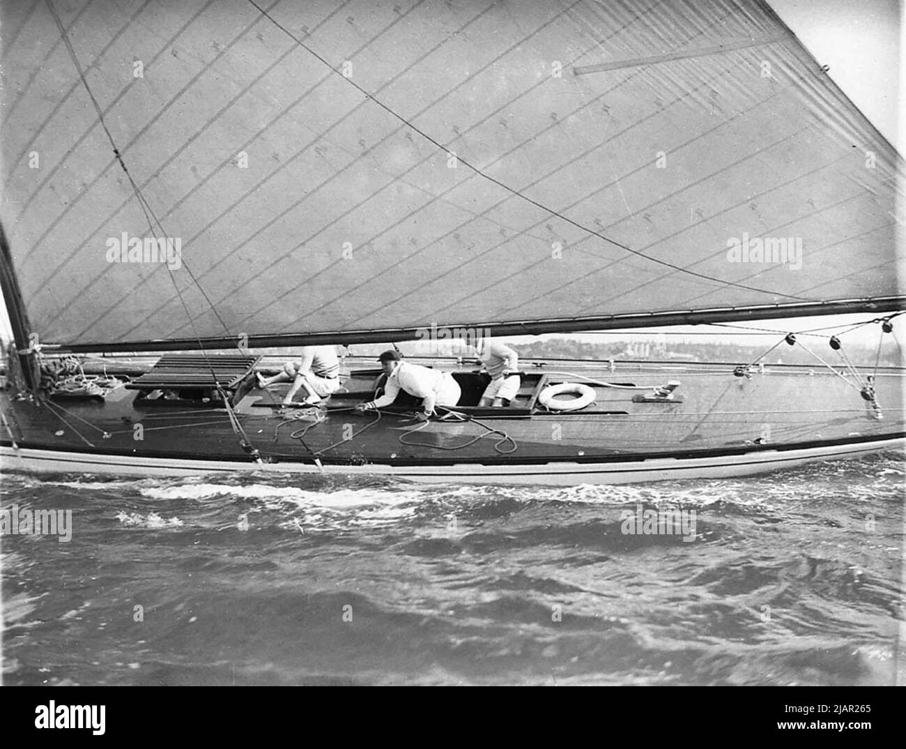 Close up of men sailing in a yacht, making a turn ca.  1930s Stock Photo