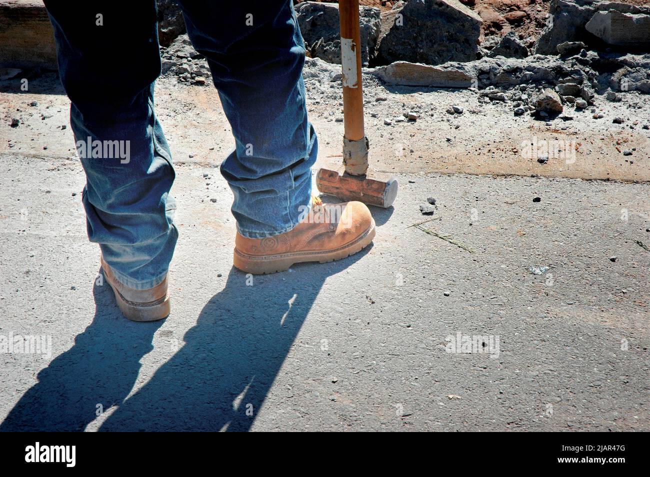 using Bobcat and hand sledge sledgehammers to level and clean dirt site of new home for cement