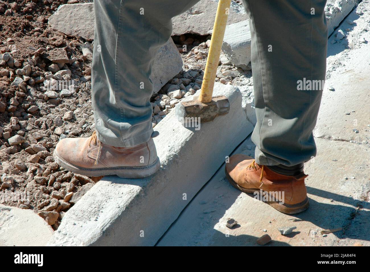 using Bobcat and hand sledge sledgehammers to level and clean dirt site of new home for cement