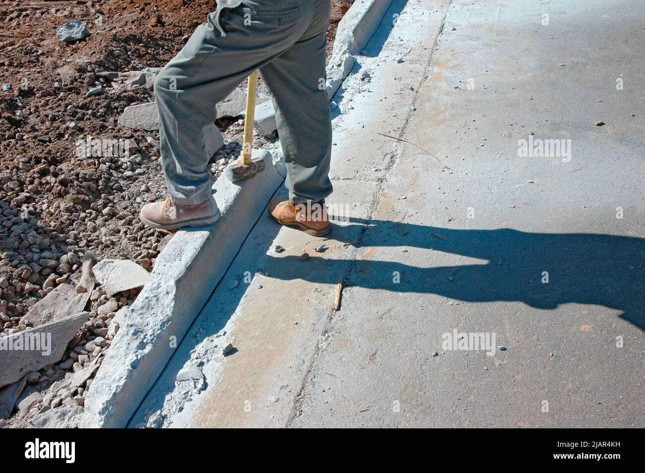 using Bobcat and hand sledge sledgehammers to level and clean dirt site of new home for cement