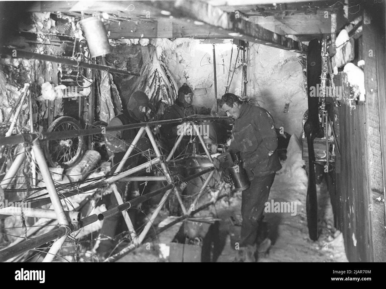 Work on the air-tractor sledge in hangar during the Australasian Antarctic Expedition. Left to right: Edward Bage, Belgrave Ninnis and Frank Bickerton ca.  1912 Stock Photo