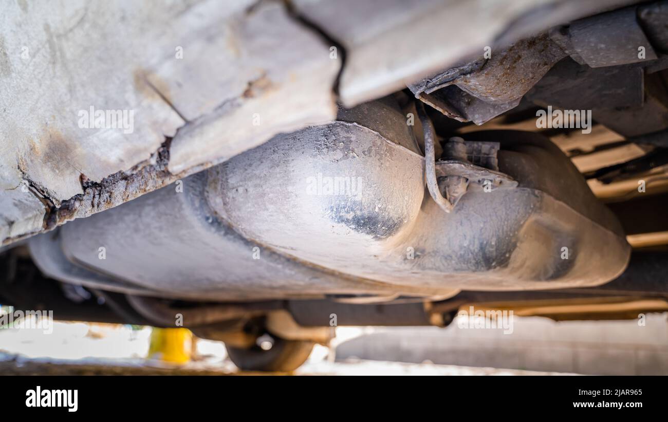 Plastic gas tank installed in a car with a rusty rotting body, bottom