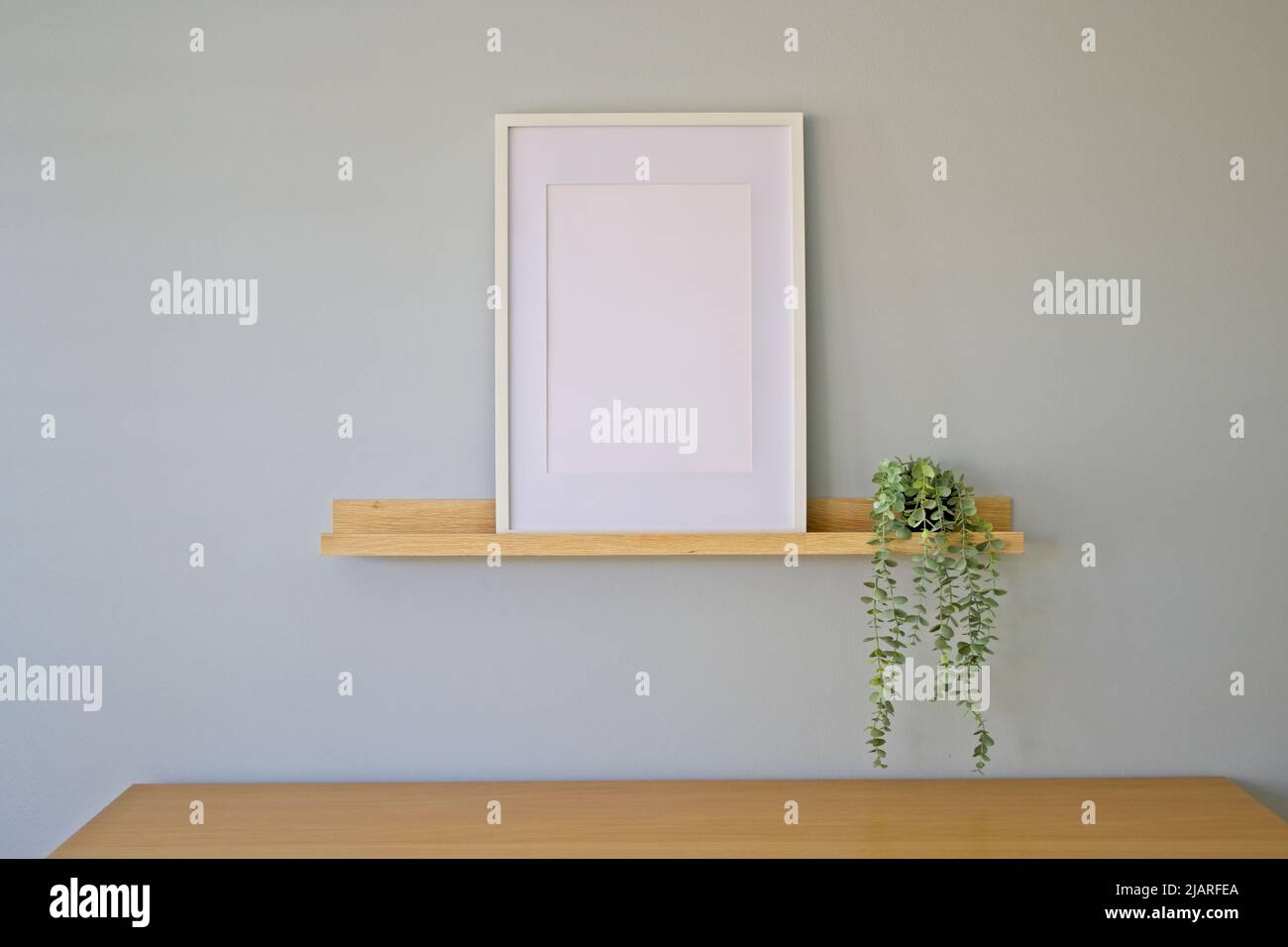 Interior frame mockup with empty frame on a wooden shelf Stock Photo
