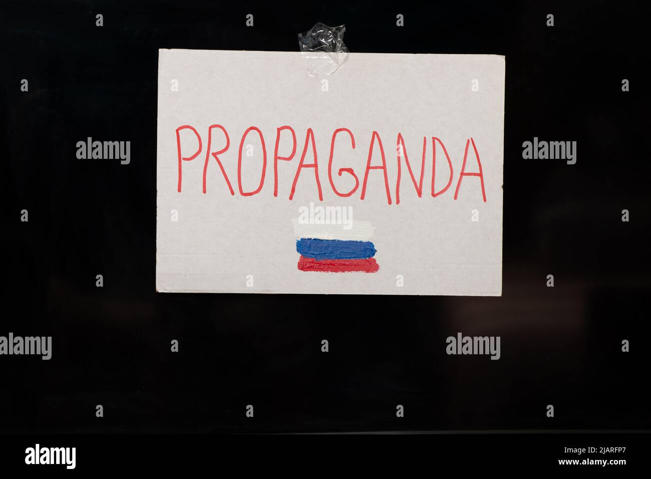 The word propaganda and the flag of Russia is written on a plate that hangs on the TV, Russian propaganda be careful, stop the war in Ukraine Stock Photo