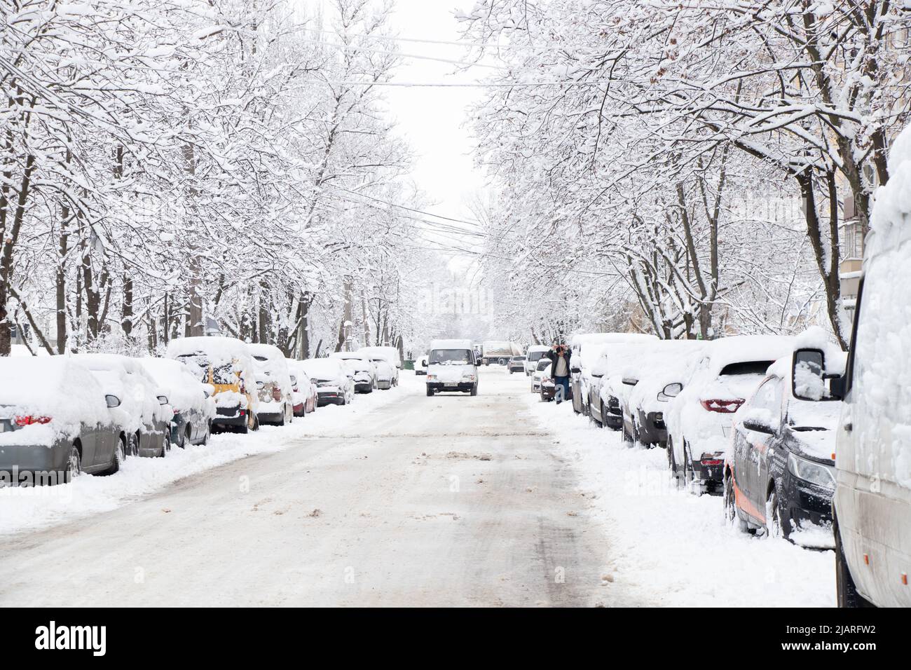Parked cars along the road in the city center near multi-storey buildings Dnipro city in Ukraine, winter in the city 2021 Stock Photo