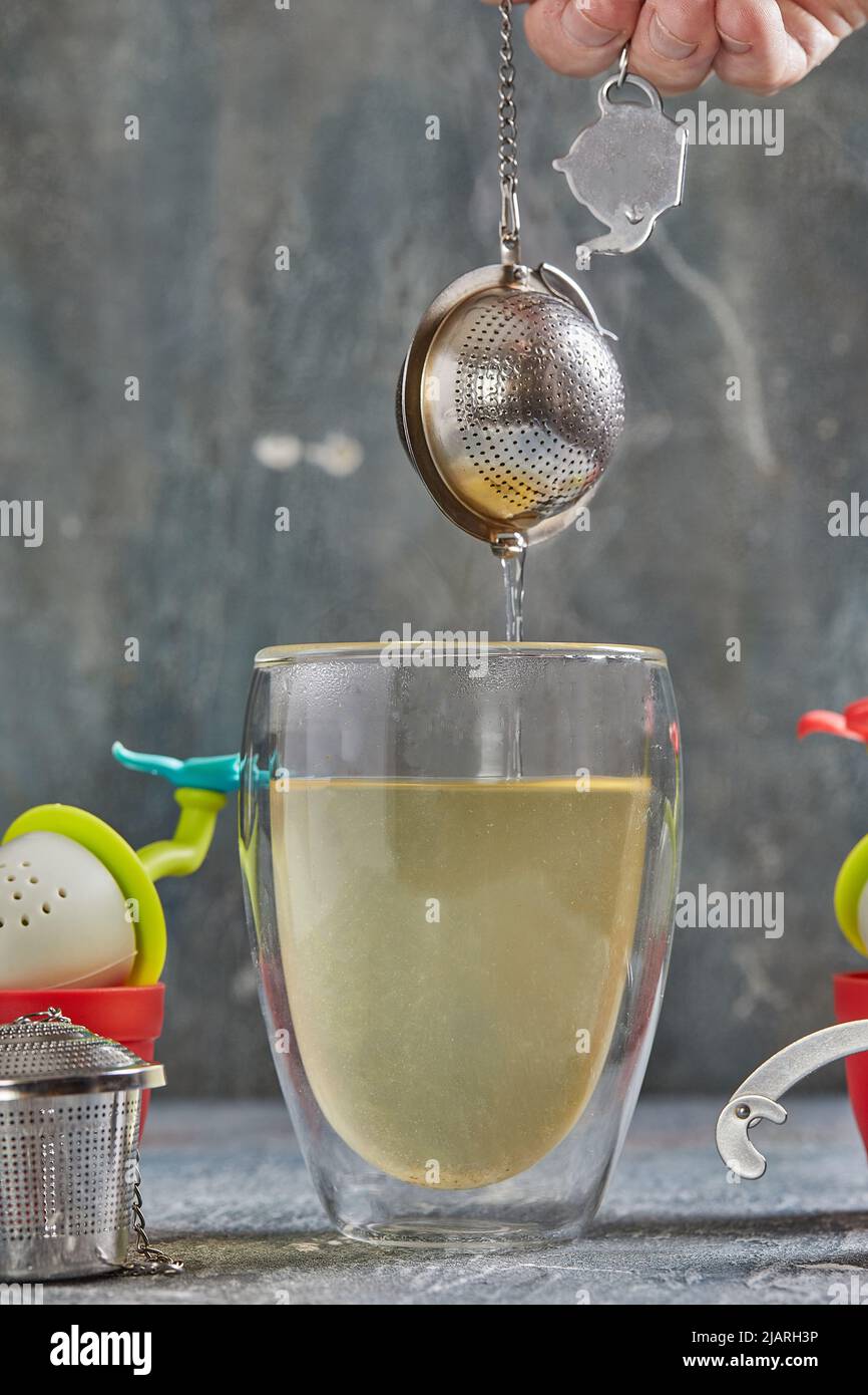 https://c8.alamy.com/comp/2JARH3P/brews-tea-in-transparent-glass-with-boiling-water-and-tea-strainer-2JARH3P.jpg
