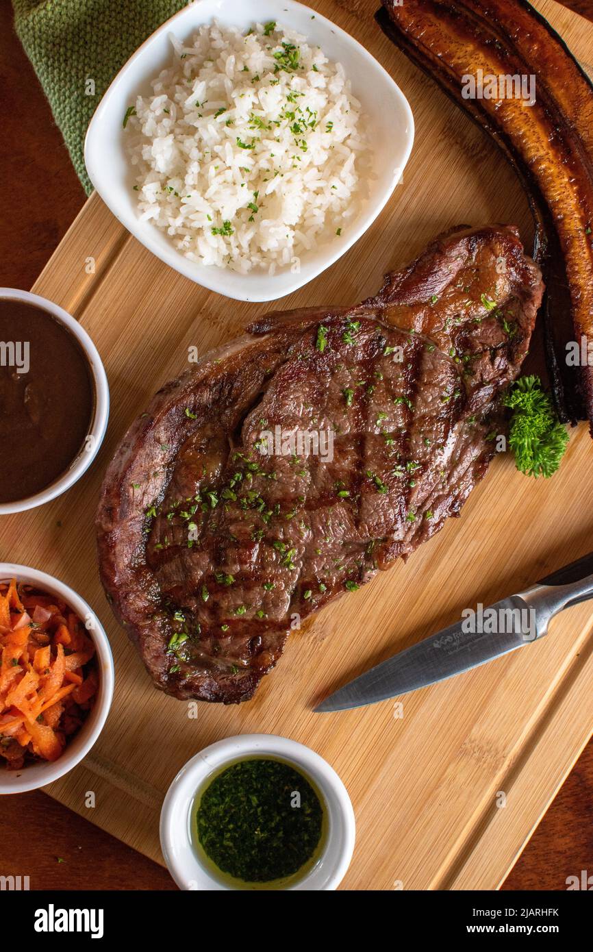 Angus beef grill with 3 sides and rice sauce wood table with a knife Stock Photo