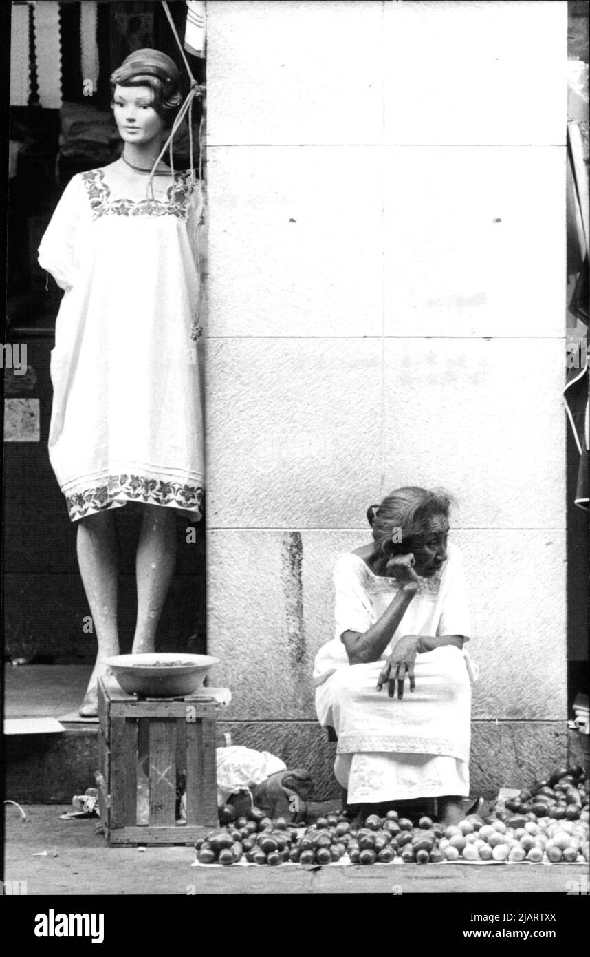 Die Abbildung zeigt eine Straßenhändlerin vor einem Modegeschäft in Merida, Mexiko. Stock Photo