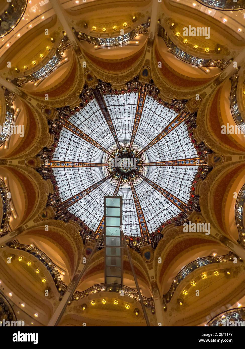Paris, France - April 6, 2022: Directly below of Galleria la Fayette glass ceiling. Colorful stained glass ceiling at daytime inside shopping mall. Stock Photo