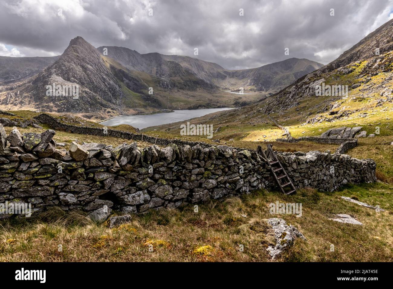 Snowdonia Landscape with Dry Stone Wall and Stile, Lake Ogwen and Tryfan Stock Photo