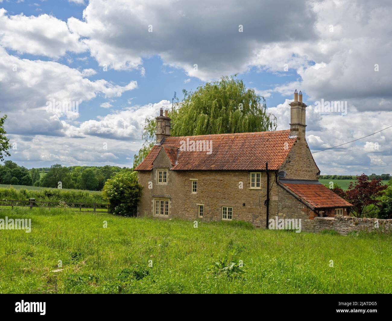 Honey coloured detached stone built house overlooking  open countryside on the edge of the village of Castle Ashby, Northamptonshire, UK Stock Photo