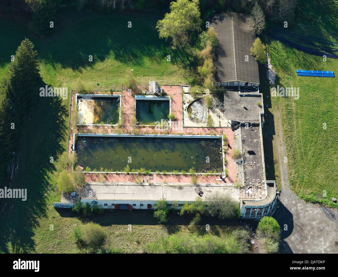 AERIAL VIEW. Abandoned swimming pool overgrown by vegetation. Saint-Léger-les-Mélèzes, Hautes-Alpes, France. Stock Photo
