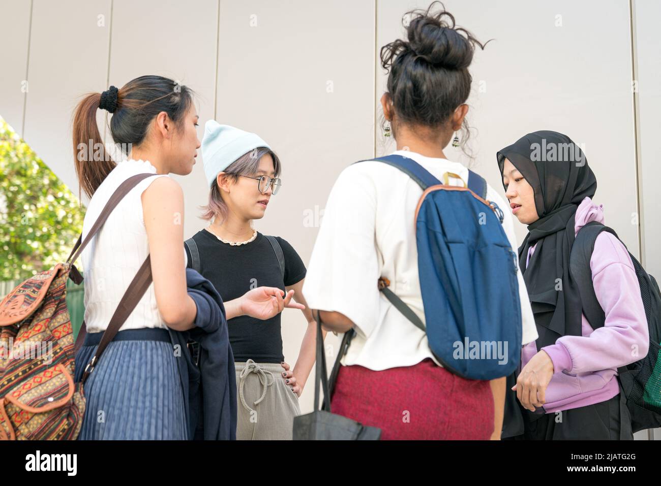Group of young college multi-racial women students standing and talking. Stock Photo