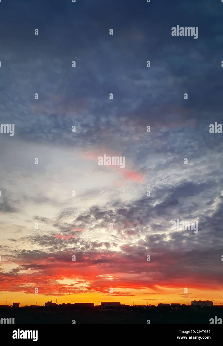 Dreamlike colorful sunset over the city horizon, vertical celestial  background Stock Photo