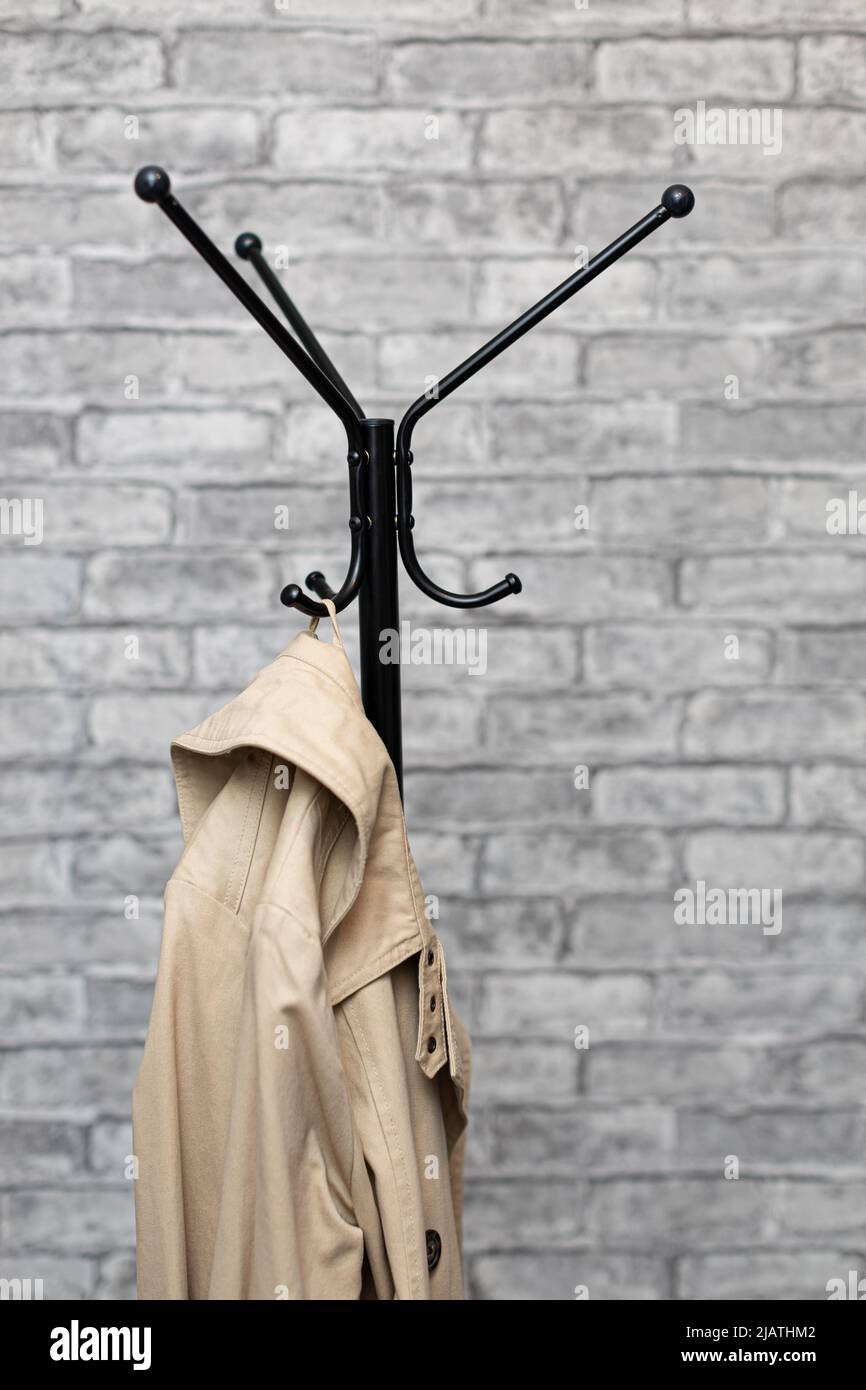 beige raincoat hanging on the hook of a floor hanger. High quality photo  Stock Photo - Alamy