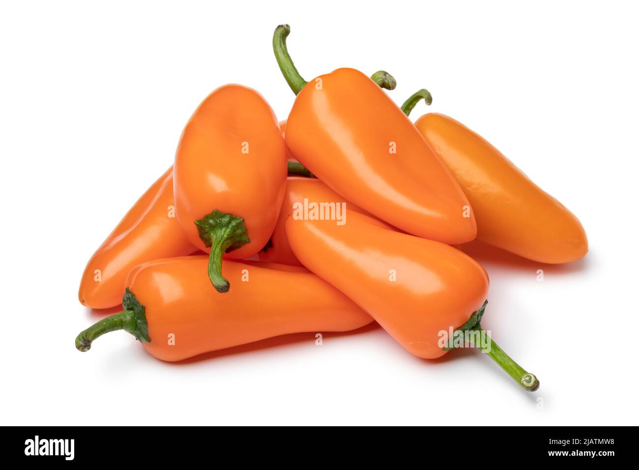 Heap of whole fresh orange mini pointed bell peppers close up isolated on white background Stock Photo