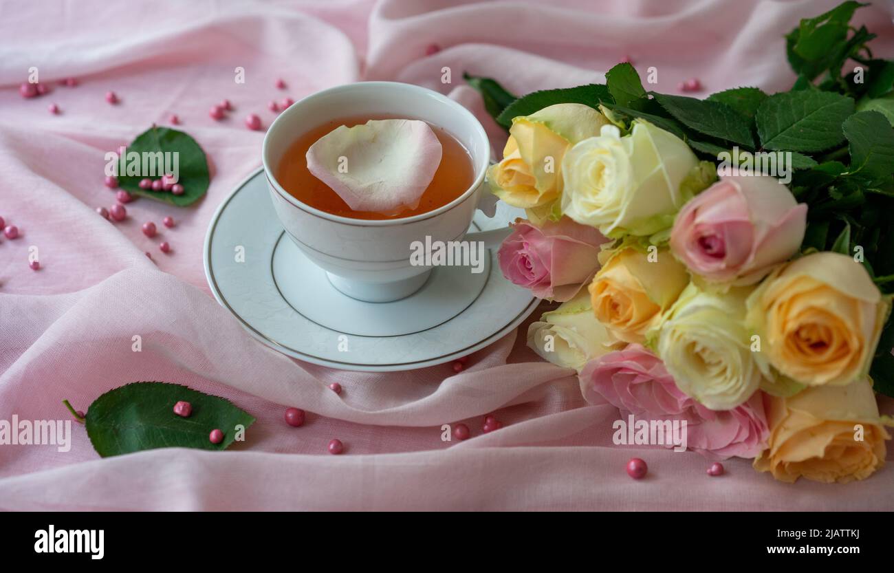 Pink rose and teacup on the pink background. closeup Stock Photo