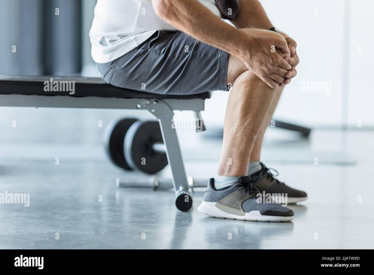 Active senior man in gym with knee injury Stock Photo