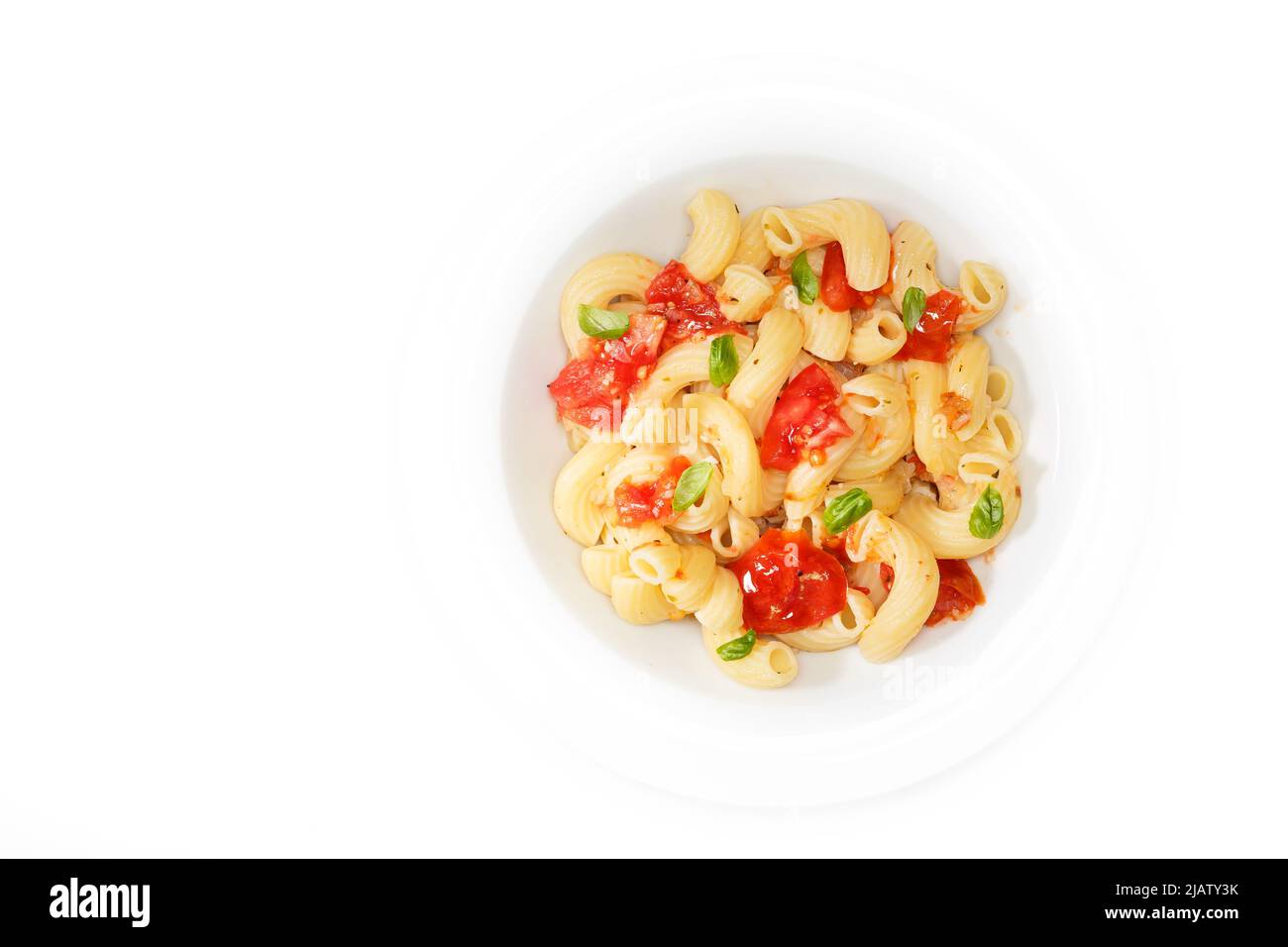 IItalian food background. Cavatappi pasta with tomatoes, spices and herb basil in a white plate. White background. With copy space for your text. Stock Photo
