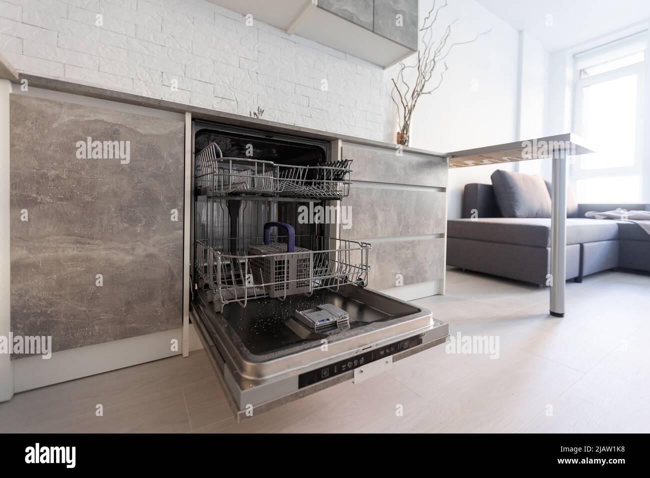 Modern kitchen with empty Builtin dishwasher with opened door