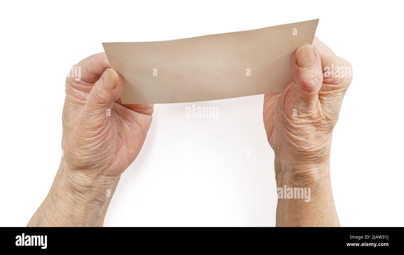Senior woman hands holding blank paper card. Isolated on white, clipping path included Stock Photo