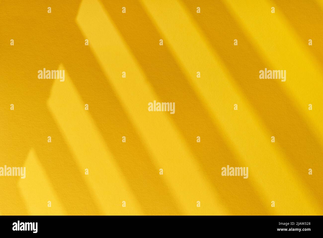 Yellow cardboard with striped windows shadows close up. Large texture and background Stock Photo