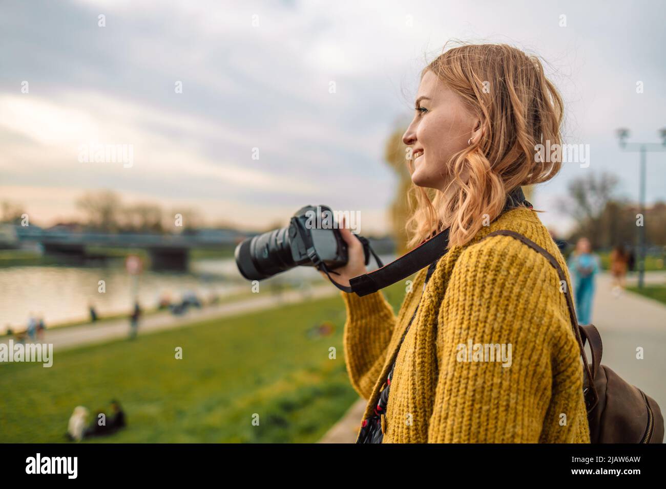Photographer traveler 30s woman in style casual clothes take photo on video camera outdoor at city view. Copy space mockup. Hobie adventure concept Stock Photo