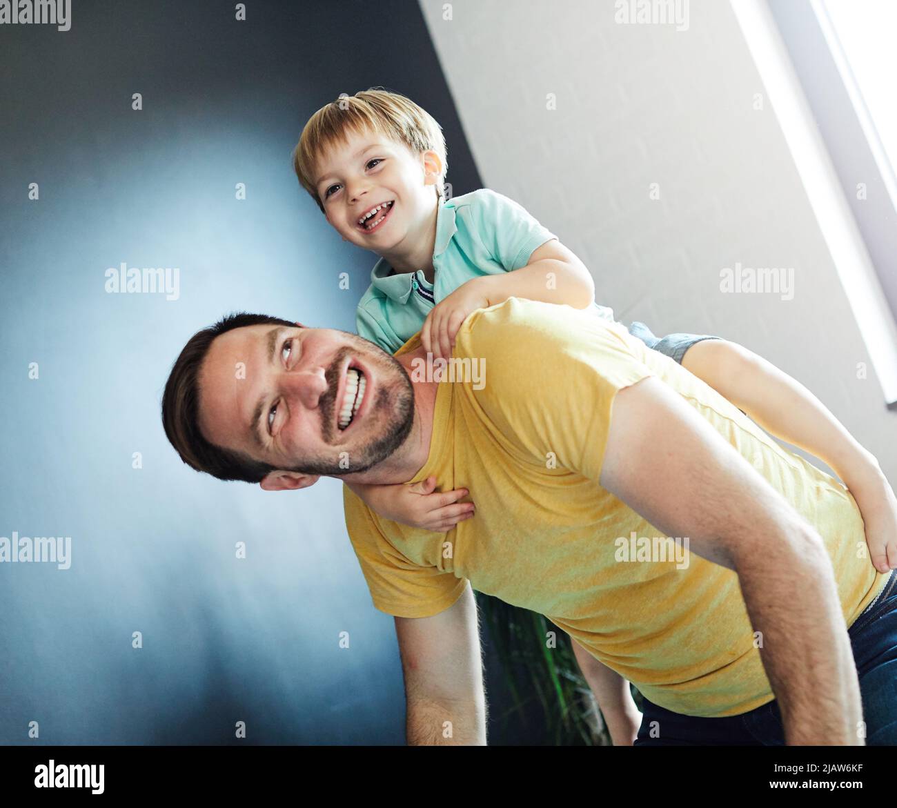 child son father family happy playing kid childhood dad love fun smiling little man home piggyback Stock Photo