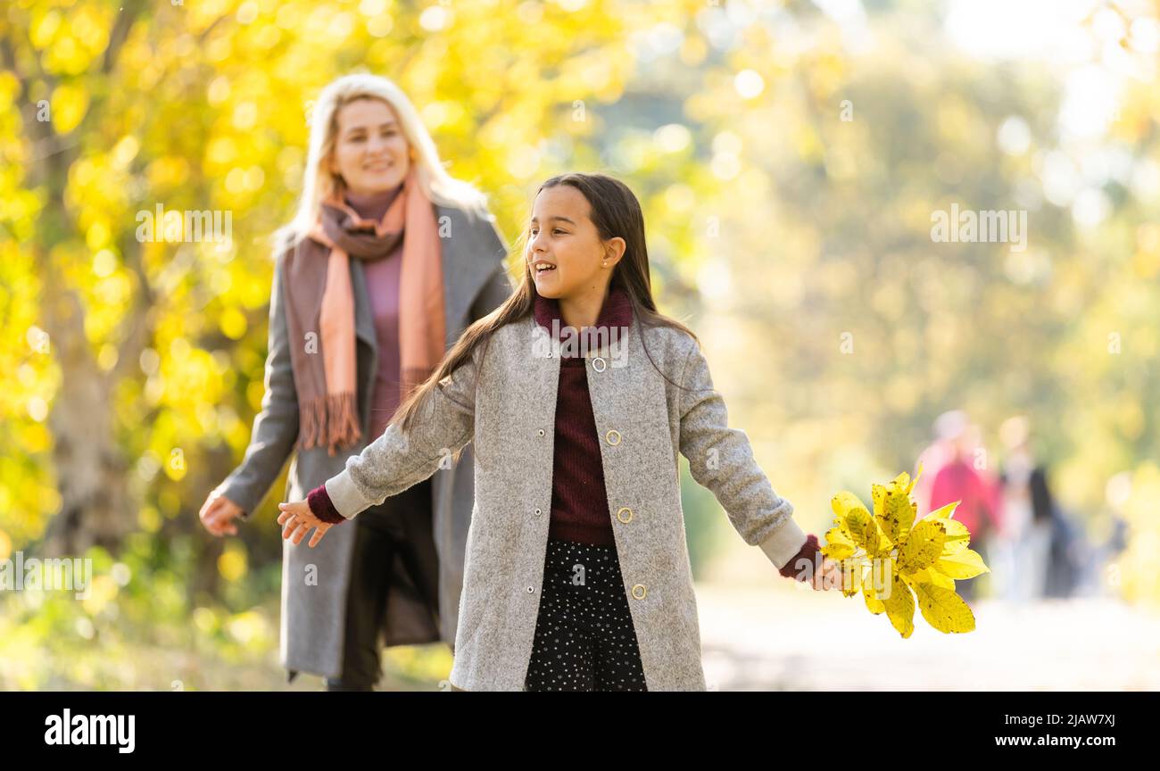 Young mother playing with her daughter in autumn park Stock Photo - Alamy