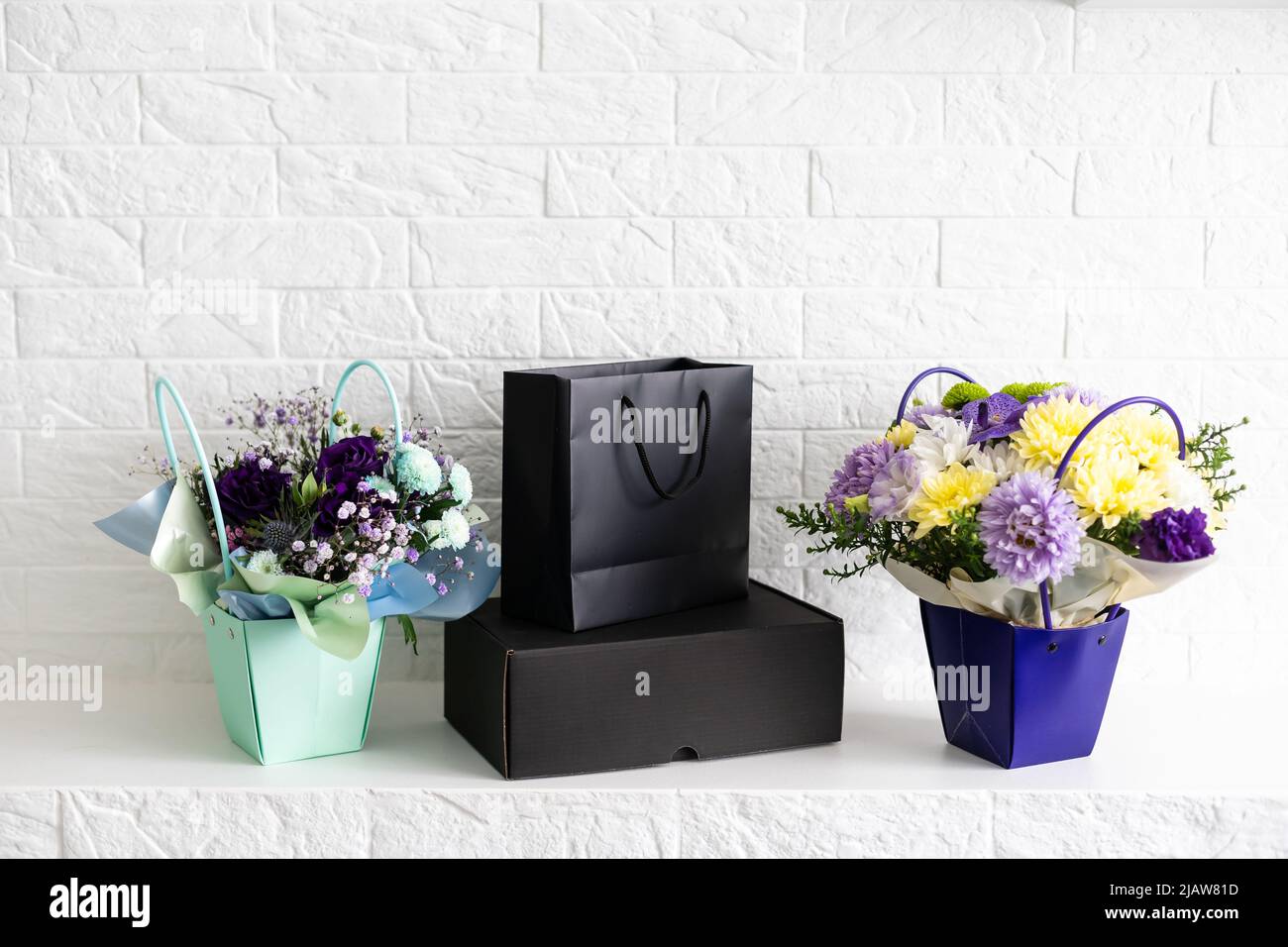 black empty paper bags and bouquets. Blank wall Stock Photo