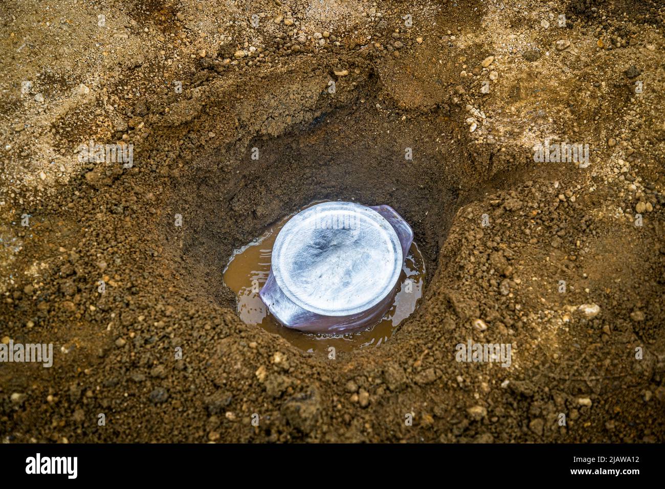 Bread pot with lid and wrapped in foil and in a hole in the ground at ...