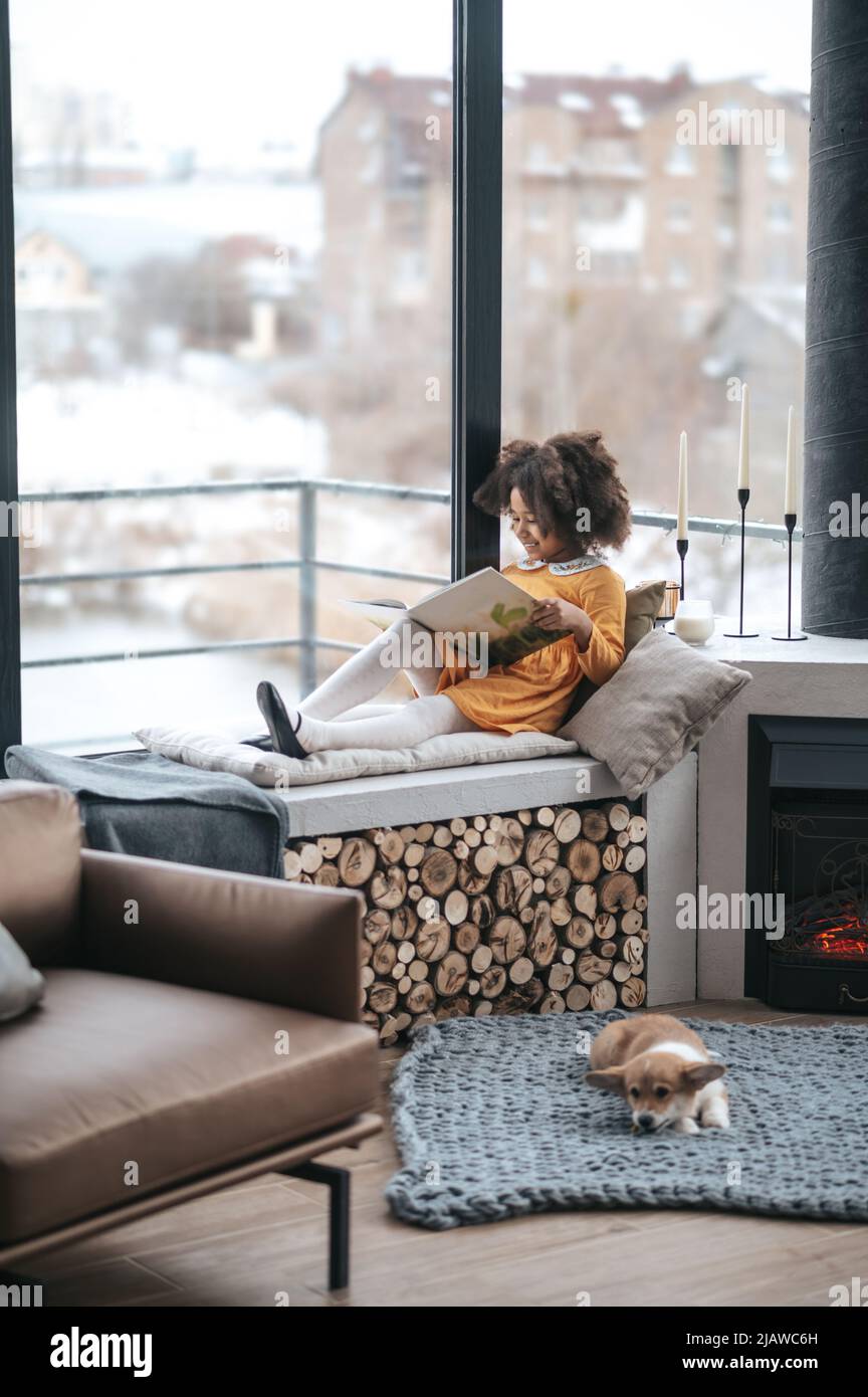 Read On Window A girl reading a book on the window Stock Photo - Alamy