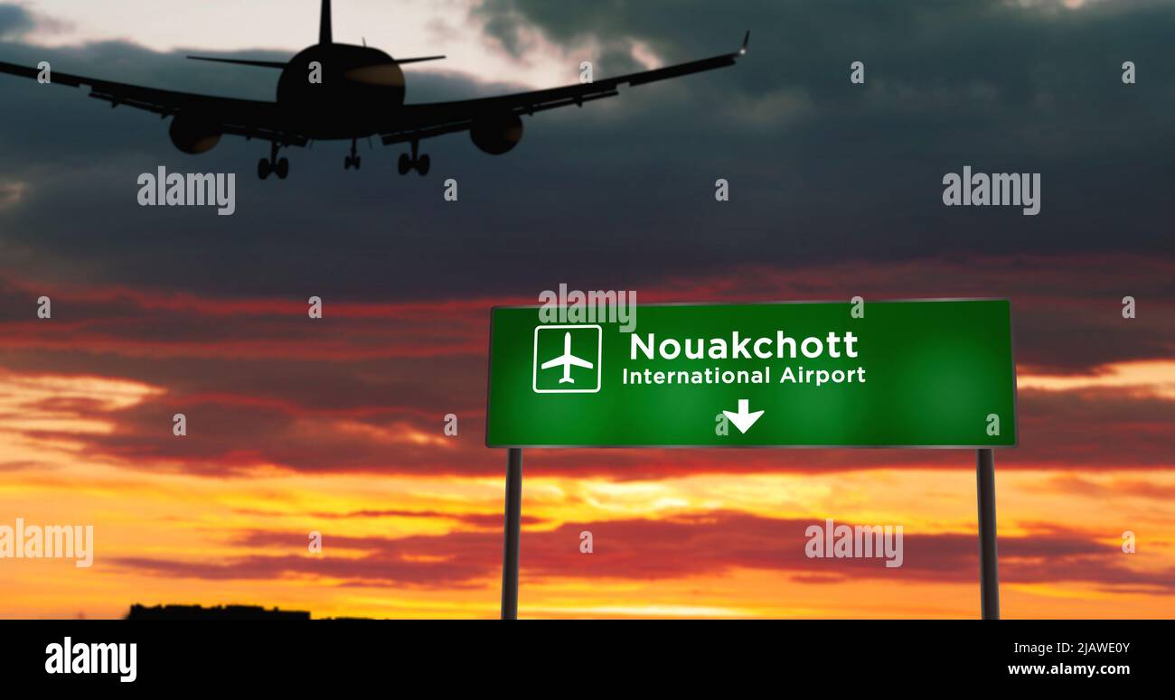 Airplane silhouette landing in Nouakchott, Mauritania. City arrival with airport direction signboard and sunset in background. Trip and transportation Stock Photo