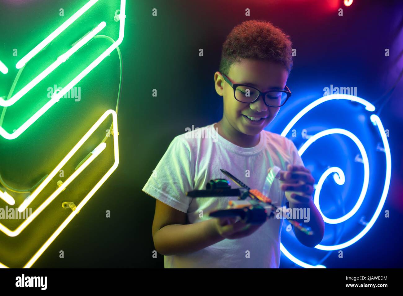 Boy engrossed in a game with a toy helicopter Stock Photo