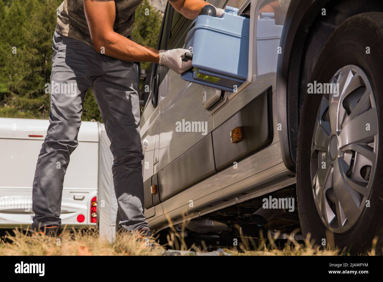 Caucasian Men Removing Toilet Cassette From His Camper Van RV