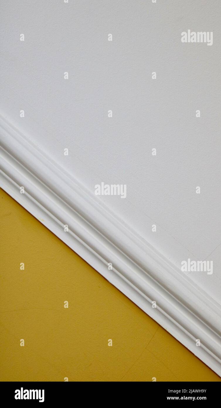 Interior image of diagonal white dado rail with yellow below and white above Stock Photo