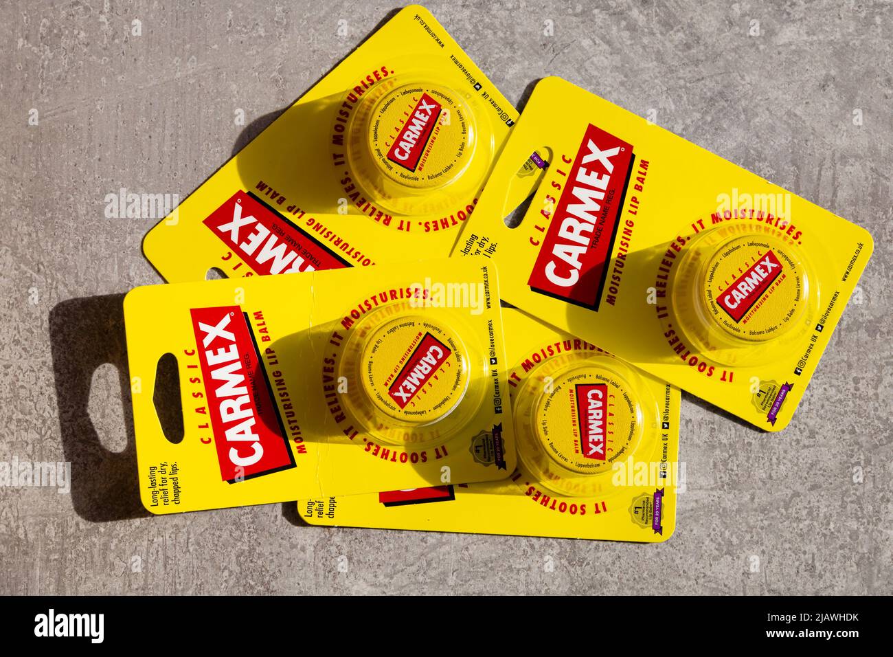 4 packs of classic Carmex moisturising lip balm in bubble packs. Yellow with red logo and writing. Stock Photo